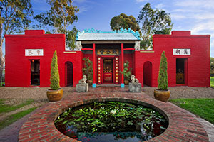 Bright red Bendigo Joss House Temple exterior with fish pond